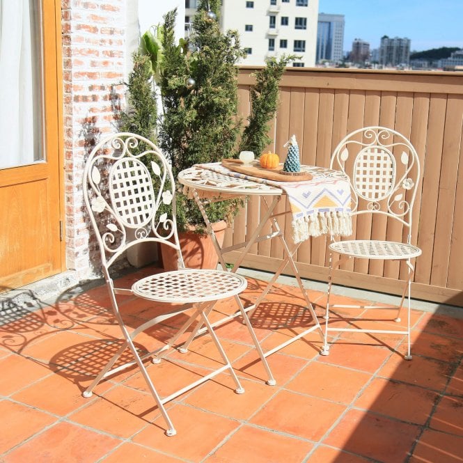 a white bistro set on a patio