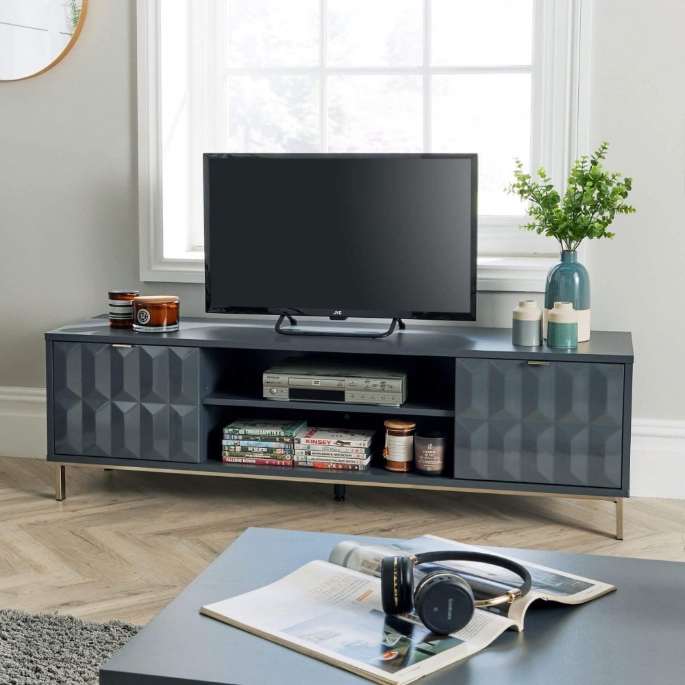 Modern navy tv stand with doors on either side and open shelves in the middle. The shelves are decorated with ornaments and a television is on top in the middle with a plant to the side.